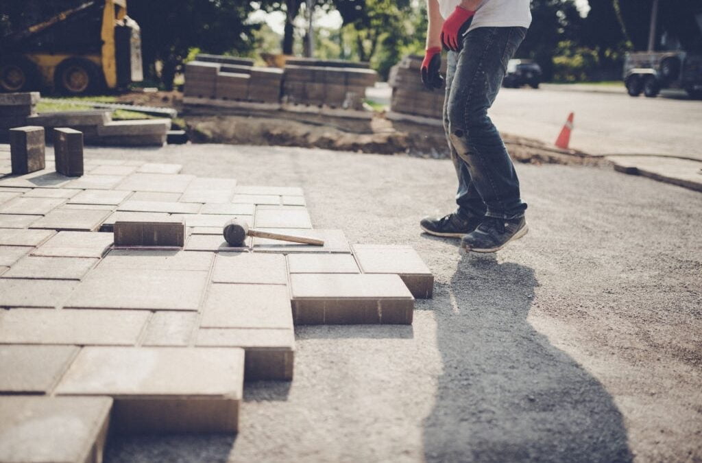 concrete contractor installing paving stones for a new driveway