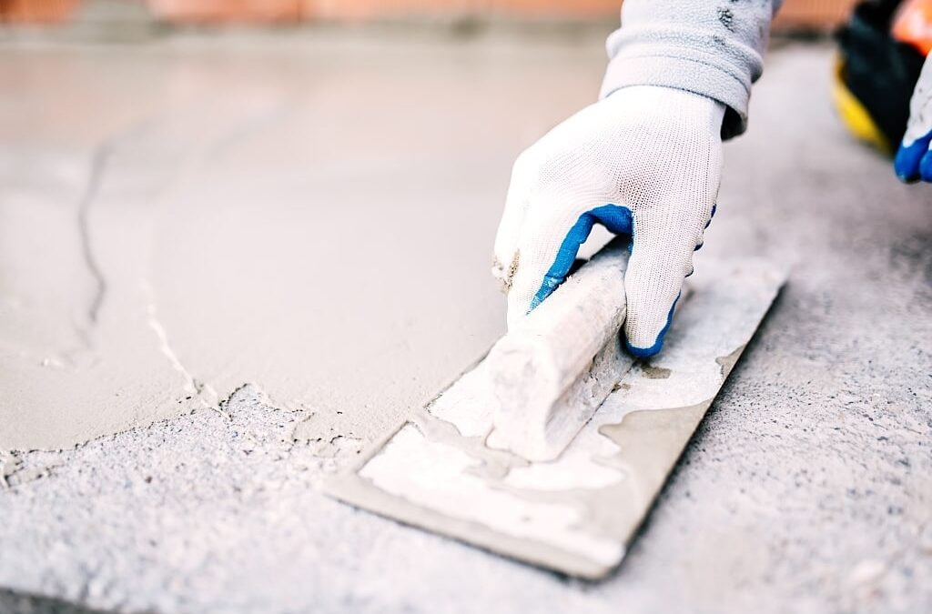 concrete contractor on construction site laying sealant for waterproofing cement